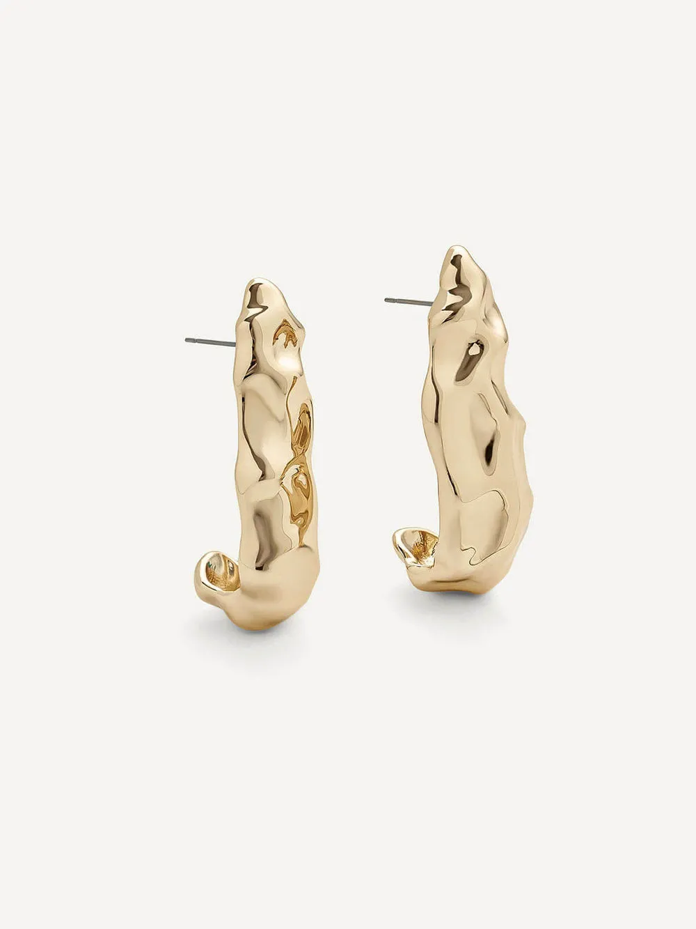 A pair of gold-toned abstract hoop earrings with textured, organic shapes and post backings, displayed on a clean off-white background.